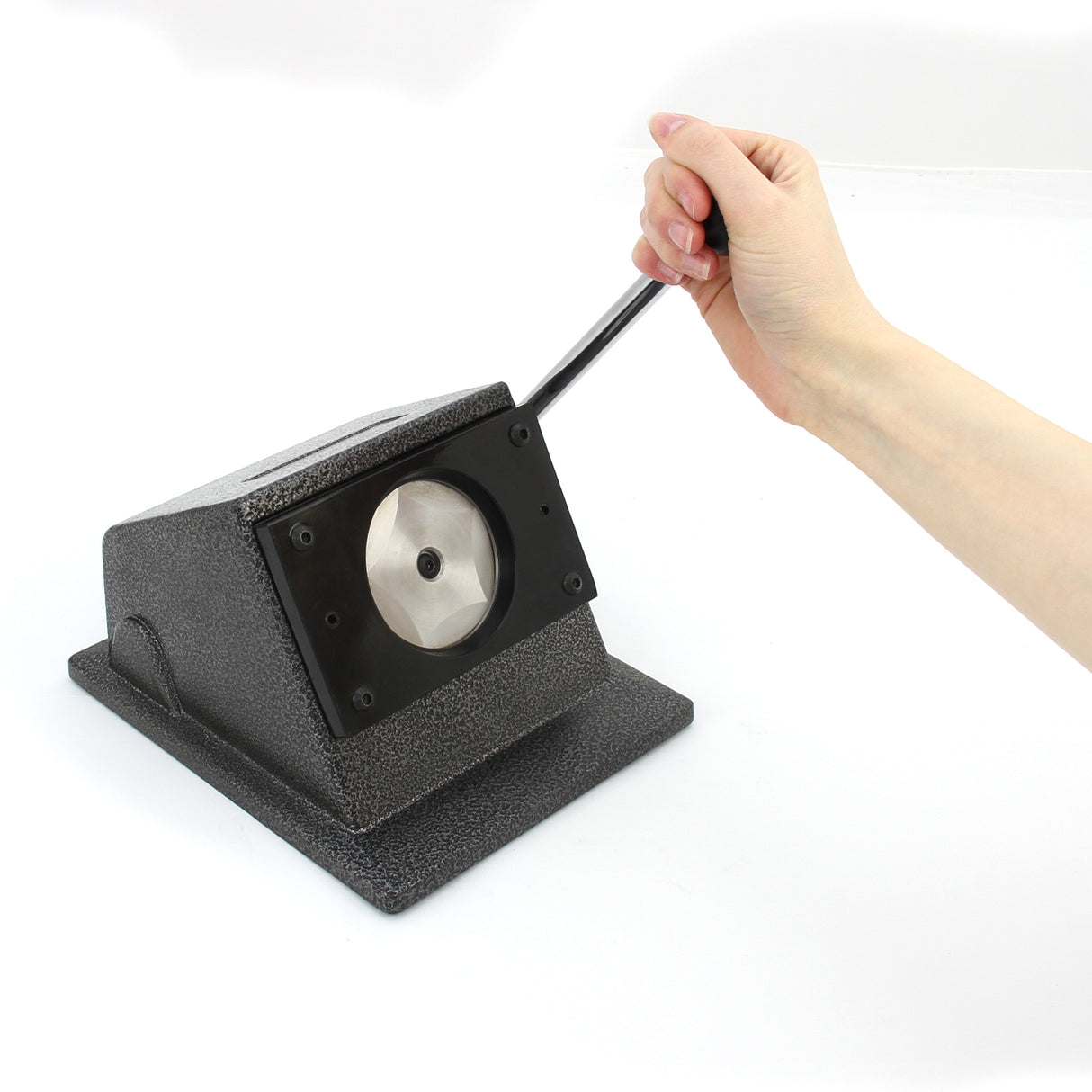 Hand using the PixMax 37mm badge press and cutter, featuring a sturdy black base and a shiny circular cutting plate
