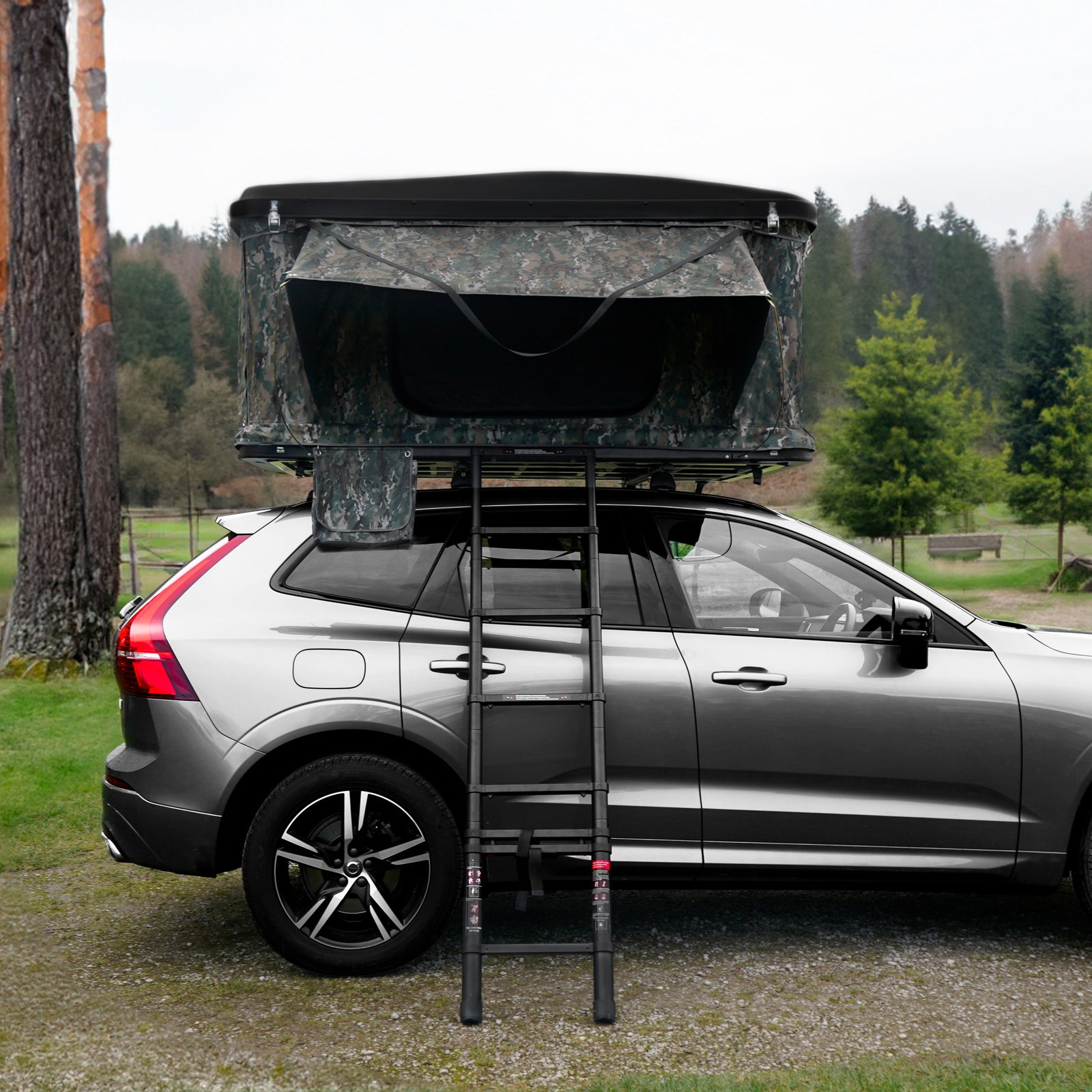 Rooftop tent in camouflage fabric mounted on a silver SUV, with a sturdy ladder leading up to the tent, surrounded by greenery