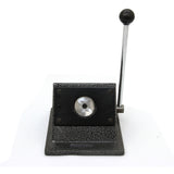 Heavy-duty badge maker with a textured black base, silver lever, and circular cutting area for creating custom badges