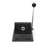 Heavy-duty badge maker with a textured black base, silver lever, and circular cutting mechanism for crafting custom badges